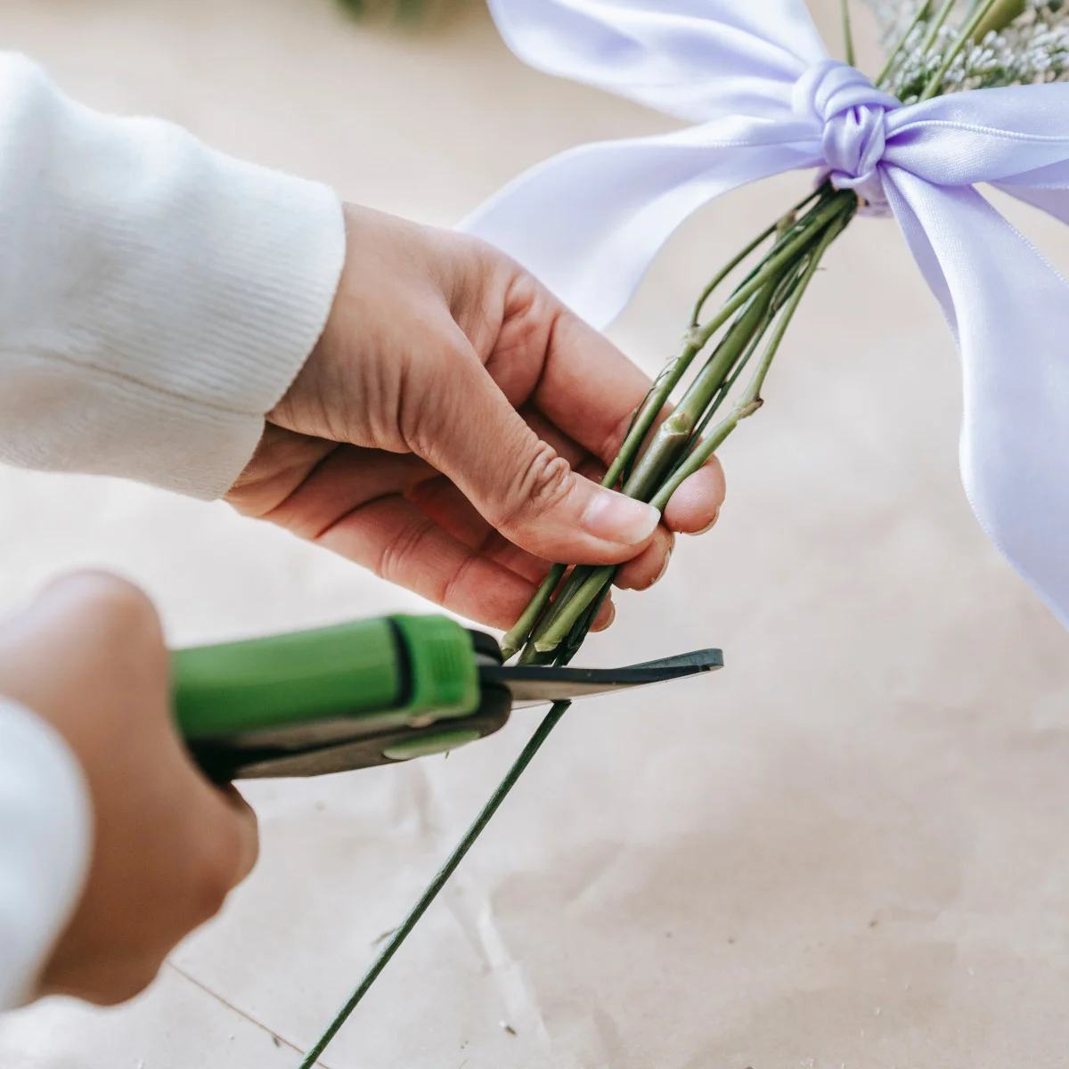 Florista cortando tallos de ramo floral
